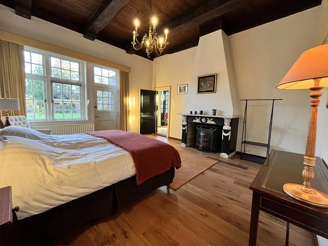 De Orangerie — slaapkamer met balkenplafond en open haard